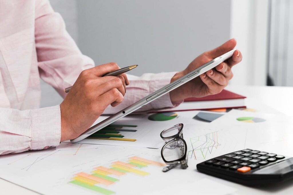 accounting, calculator, pen, graph paper, glasses, tablet, data analysis, filled graphs, office work, business analysis, financial documents, sustainability, professional services, smart devices, from the table, remote work, corporate finance, busy time, organizational skills, strategic planning
